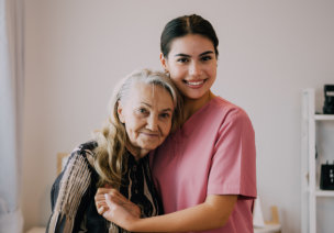 Female caregiver hugged the elder woman at home