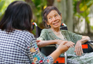 Elder woman on a wheelchair are smiling