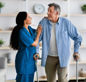 Senior man standing while holding his crutches