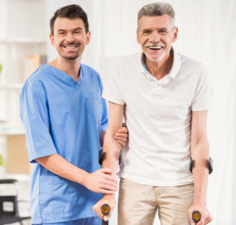 Smiling elder man holding his crutches