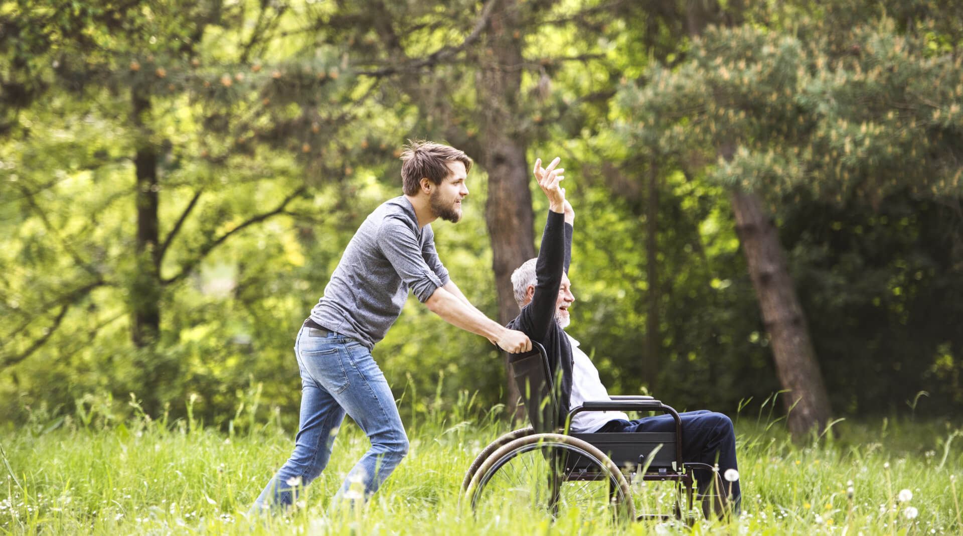 Man push the wheelchair of the elder man