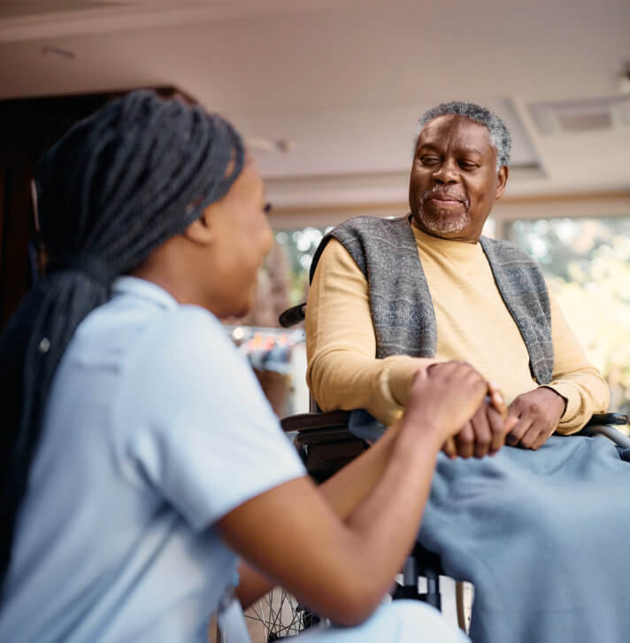 Man on a wheelchair looking at the caregiver