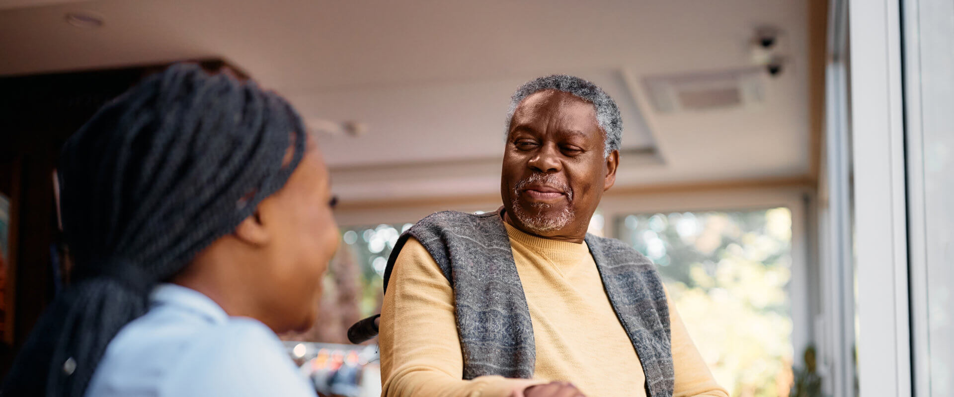 Man on a wheelchair looking at the caregiver