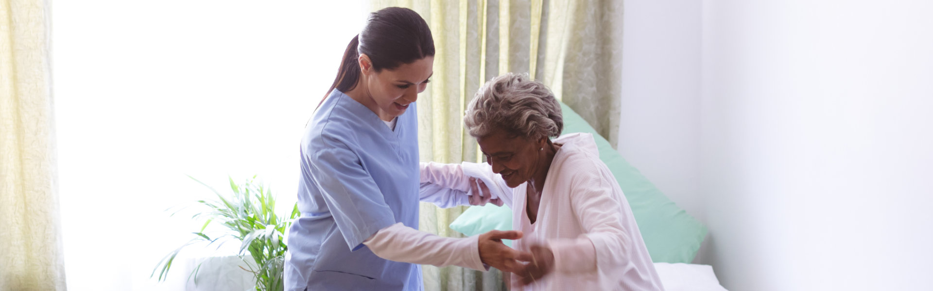 nurse helping senior woman to stand up